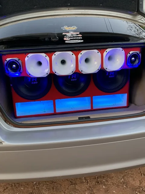 Baúl de sedán con caja roja, drivers blancos y luz azul