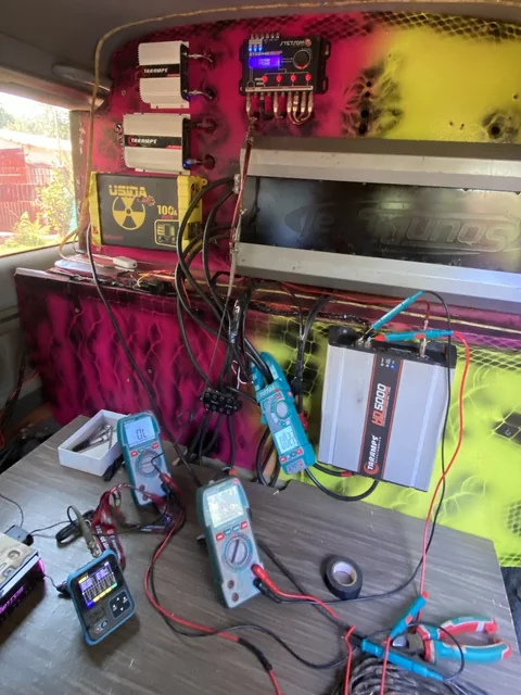 Módulos amplificadores y cableado medidos con varios tester sobre una mesa